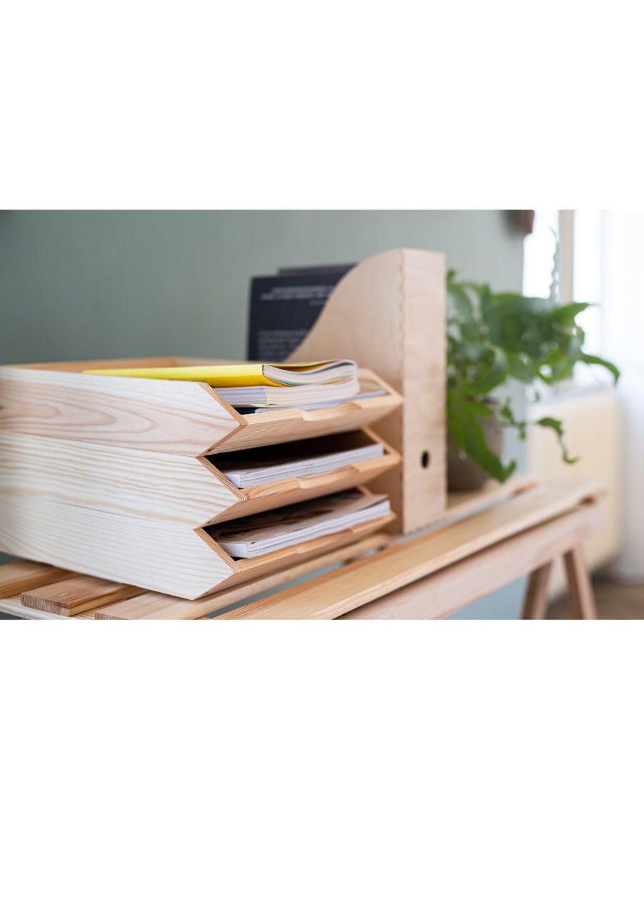 Neatly organised desk with paper trays and plant